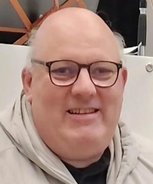 Das Foto zeigt Bernd Altenkirch. Er hat eine schwarze Brille und lächelt freundlich.